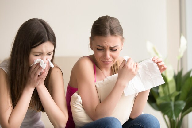 Due amici delle giovani donne che gridano insieme a casa