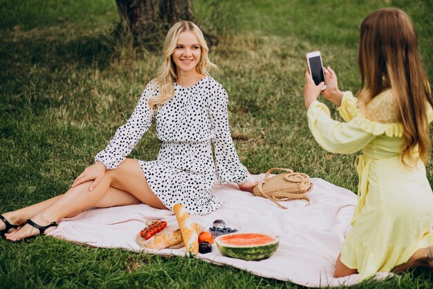 Due amici di ragazze che hanno picnic nel parco