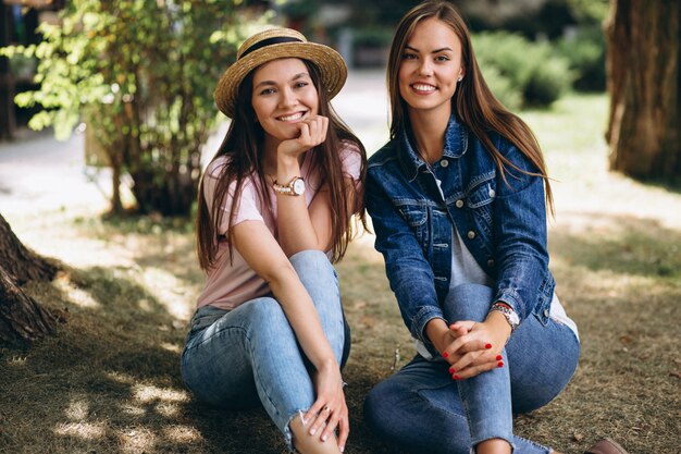 Due amici di ragazze che si siedono nel parco