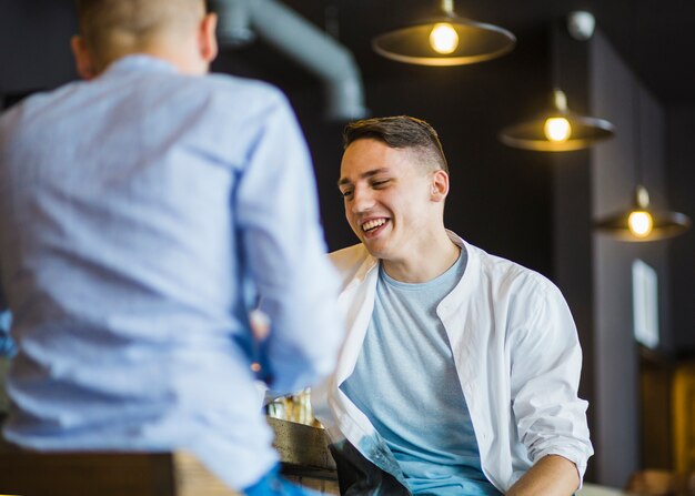 Due amici maschii che si siedono nel ristorante