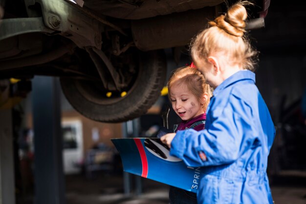 Due bambine in tuta con la rivista di lettura chiave