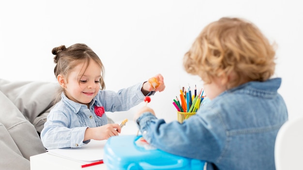 Due bambini che giocano insieme alla scrivania