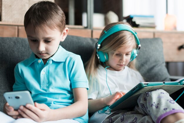 Due bambini con tablet e smartphone