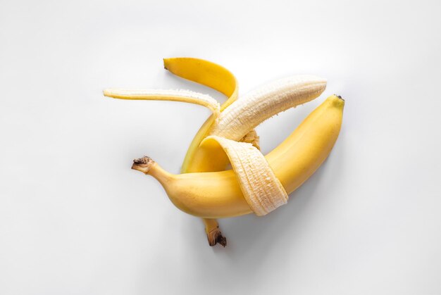 Due banane su uno sfondo bianco hanno isolato il minimalismo concettuale