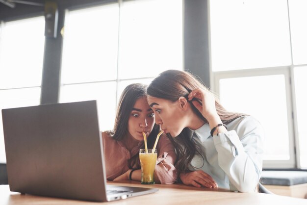 Due belle ragazze gemelle passano il tempo a bere succo di frutta.