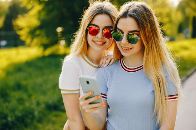 due belle ragazze giovani belle con capelli biondi lucenti e una gonna e camminare