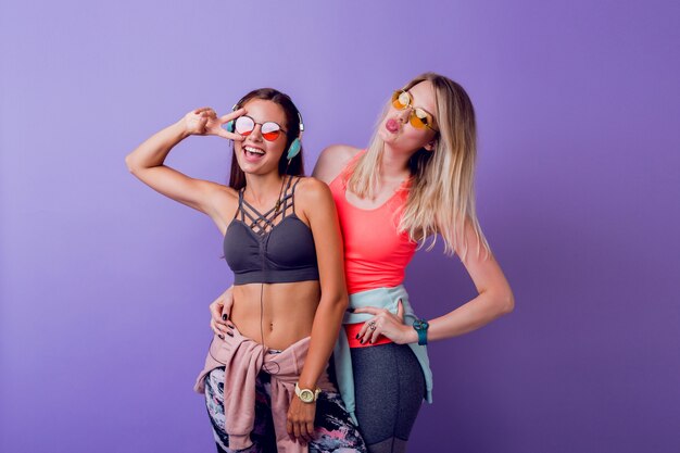 Due belle ragazze in activewear alla moda in posa sul purpl