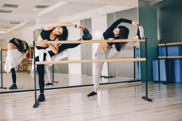 due belle ragazze snelle che fanno danza e ginnastica nella sala da ballo