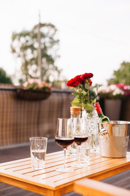 Due bicchieri di vino e rose su un ristorante all&#39;aperto