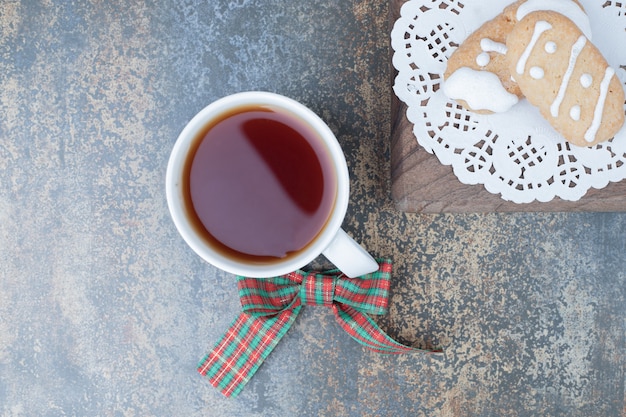 Due biscotti di Natale e una tazza di tè su fondo di marmo. Foto di alta qualità