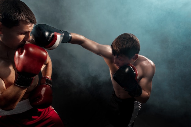 Due boxer professionisti boxe su nero fumoso,