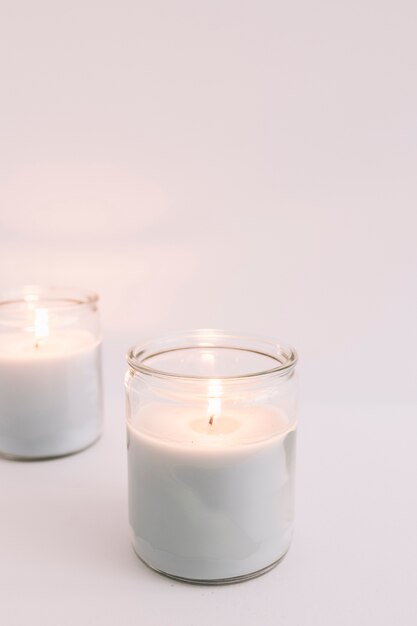 Due candele accese in candelieri di vetro