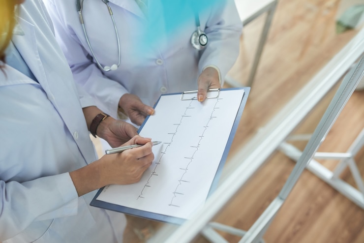 Foto gratuito due cardiologi ritagliati che esaminano i cardiogrammi nell'ufficio medico