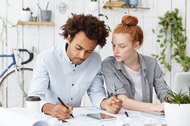 Due colleghi creativi che lavorano insieme alla scrivania in ufficio