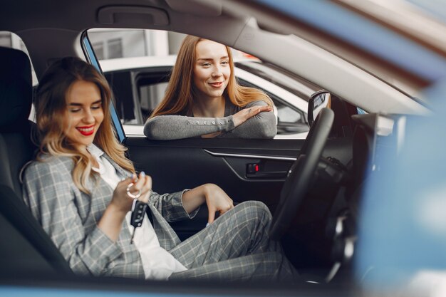 Due donne alla moda in un salone di auto