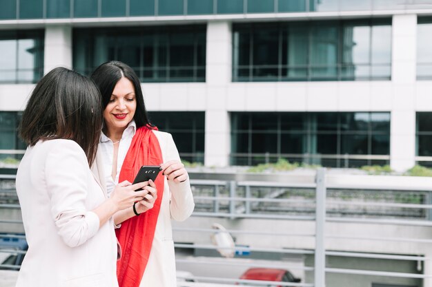 Due donne che guardano al telefono cellulare