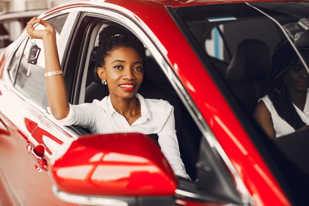 Due donne di colore alla moda in un salone di auto