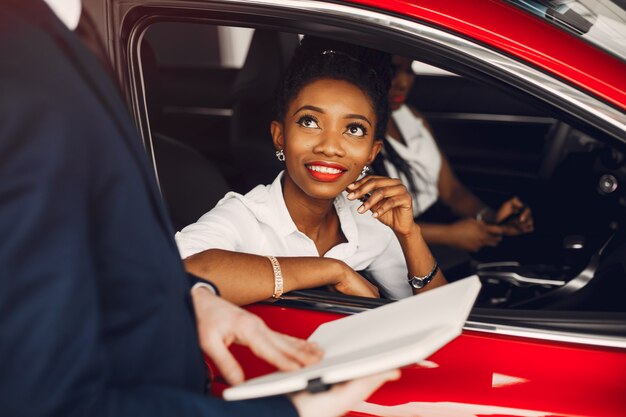 Due donne di colore alla moda in un salone di auto