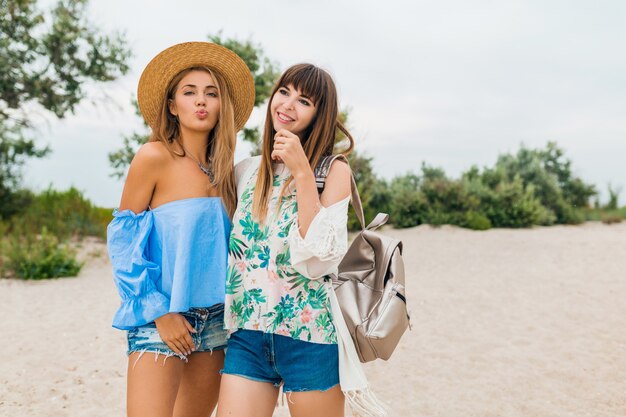 Due donne eleganti e sorridenti durante le vacanze estive, gli amici viaggiano insieme, l'abbigliamento da spiaggia alla moda