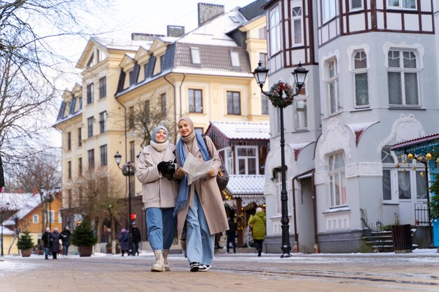 Due donne musulmane che camminano per la città mentre viaggiano