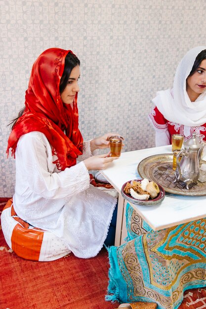 Due donne musulmane che si siedono alla tabella