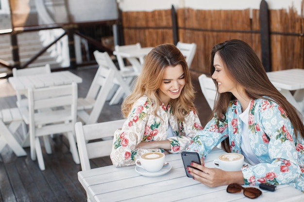 due donne sorridenti all'aperto al bar