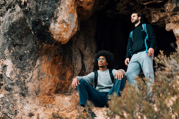 Due escursionista maschio vicino all'ingresso della grotta