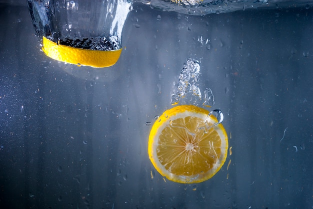 Due fette di limone cadono in acqua