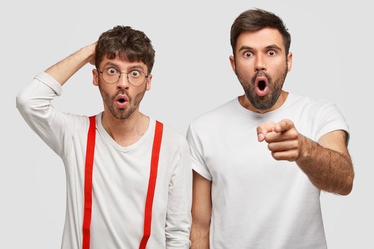 Foto gratuito due freelance emotivi dai capelli scuri notano qualcosa di terribile di fronte, reagiscono con sorpresa