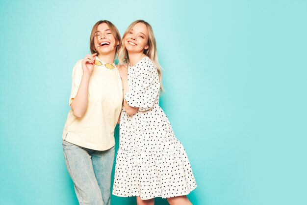 Due giovani belle donne bionde sorridenti hipster in abiti estivi alla moda