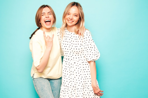 Due giovani belle donne bionde sorridenti hipster in abiti estivi alla moda