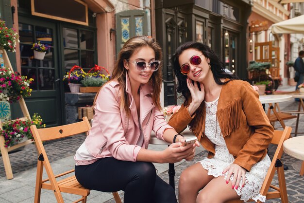 Due giovani belle donne hipster seduti al caffè