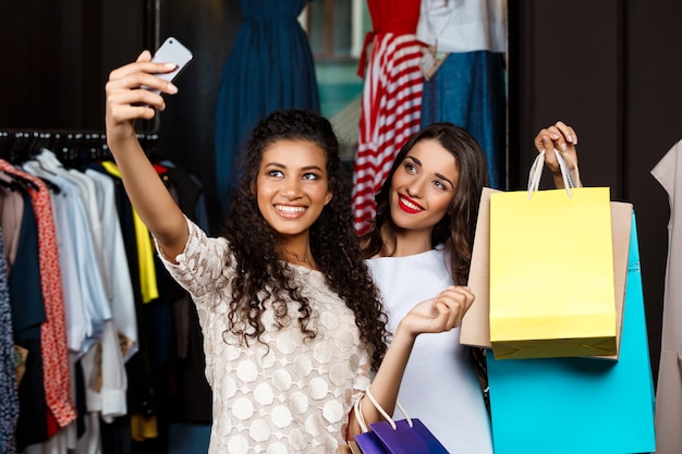 Due giovani belle ragazze che fanno selfie nel centro commerciale.