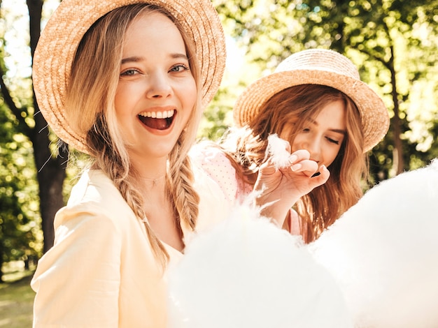 Due giovani belle ragazze hipster sorridenti in prendisole estive alla moda