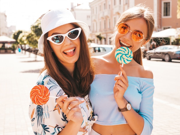 Due giovani belle ragazze sorridenti hipster in abiti estivi alla moda e cappello panama.