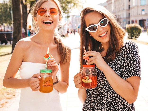 Due giovani belle ragazze sorridenti hipster in abiti estivi alla moda