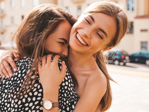 Due giovani belle ragazze sorridenti hipster in abiti estivi alla moda