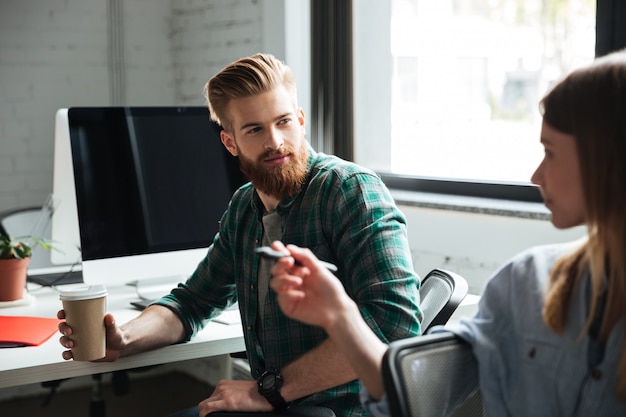 Due giovani colleghi concentrati lavorano in ufficio