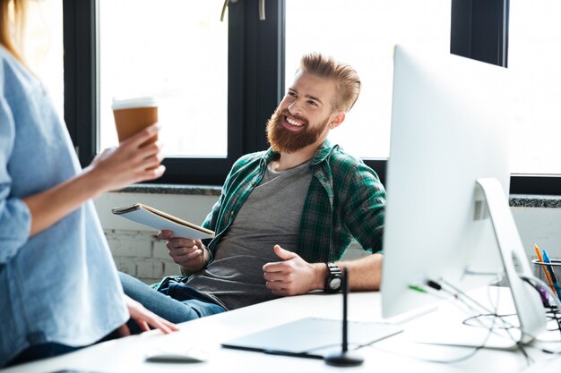 Due giovani colleghi sorridenti lavorano in ufficio