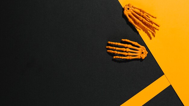 Due mani scheletro su carta arancione