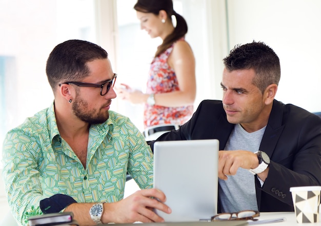 Due maschi che utilizzano pad sul posto di lavoro