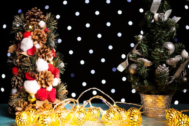 Due mini alberi di Natale sulla luce festiva del bokeh. Decorazione e vacanza. Stagionale e Capodanno