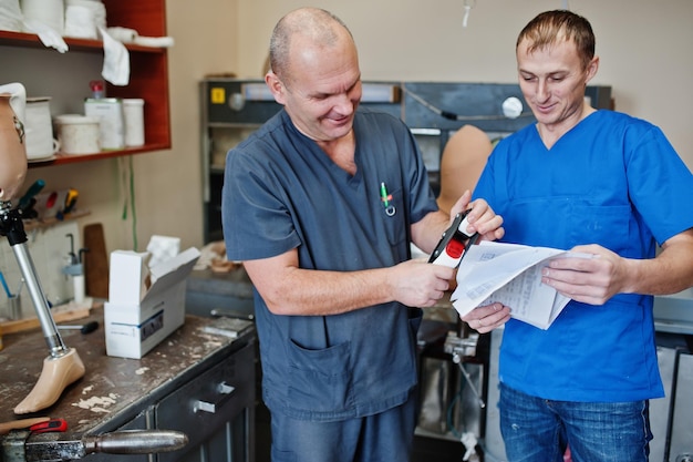 Due operai protesisti che fanno protesi di gamba mentre lavorano in laboratorio