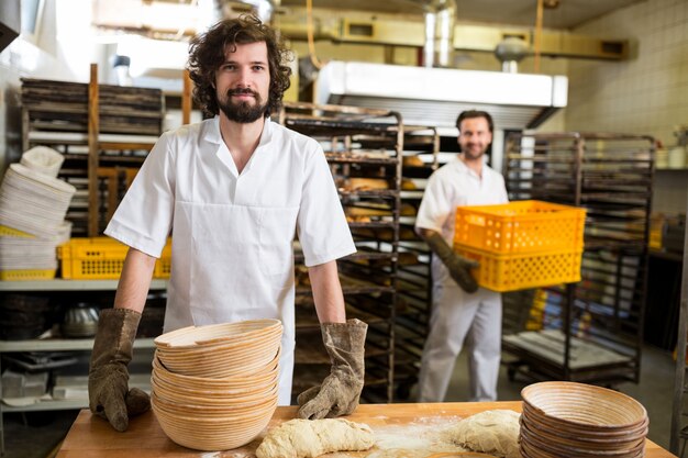 Due panettieri sorridenti che lavorano in cucina prodotti da forno