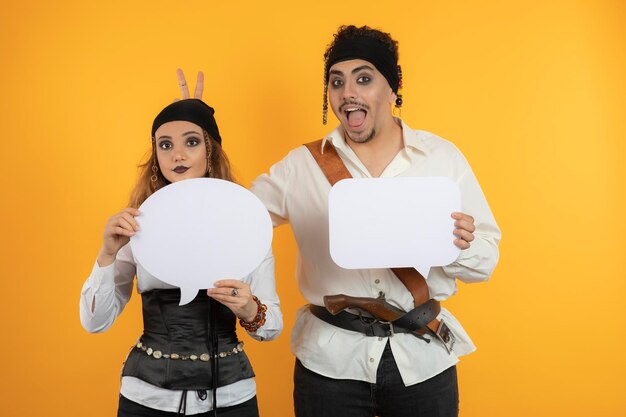 Due pirati stanno su sfondo arancione e tengono in mano schede idea bianche. Foto di alta qualità