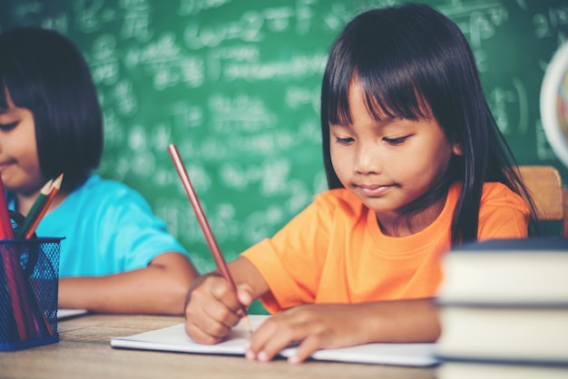 Due ragazza con il pastello che disegna alla lezione nell&#39;aula