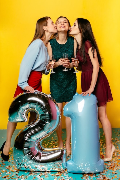 Due ragazze che baciano un&#39;altra donna, festeggiano il compleanno, passano il tempo con piacere