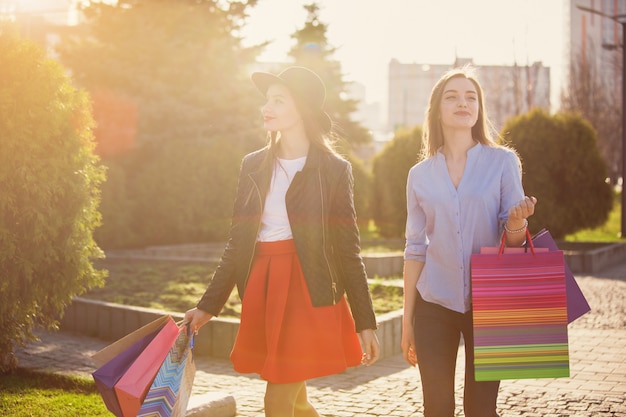 Due ragazze che camminano con lo shopping per le strade della città