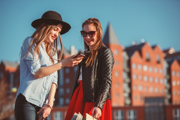 Due ragazze che camminano con lo shopping per le strade della città