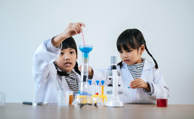 Due ragazze che fanno esperimenti scientifici in un laboratorio. Messa a fuoco selettiva.